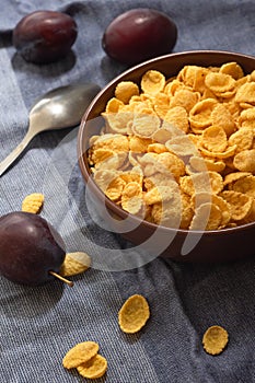 Corn flakes in a bowl on the table with fruits