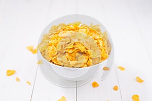 Corn flakes bowl on white wooden table