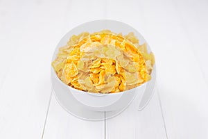 Corn flakes bowl on white wooden table