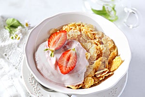 Corn flakes in bowl, yogurt, strawberries and chia seeds