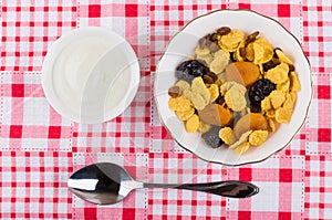 Corn flakes with dried fruits, sour cream and spoon