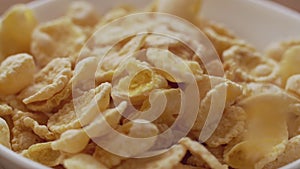 Corn flakes falling in white bowl. Close up view in 4k