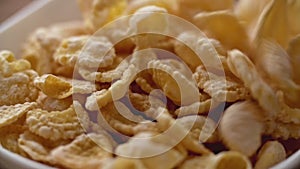 Corn flakes falling in white bowl in slow motion. Close up view