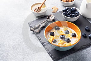 Corn flakes made from natural cereals with fresh blueberries, honey and milk. The concept of a healthy wholesome Breakfast. copy