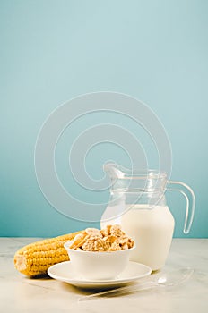 corn with flakes and milk/ corn flakes with milk and a corn ear on a blue background