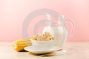 corn with flakes and milk/ corn flakes with milk and a corn ear on a pink background