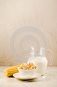 corn with flakes and milk/ corn flakes with milk and a corn ear on a white background with copy space