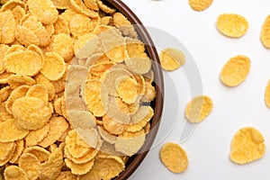 Corn flakes in a plate close-up on a white background, top view