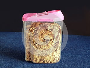 Corn flakes in transparent plastic container closeup