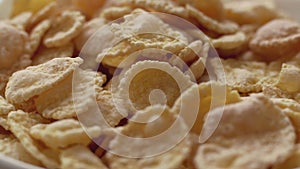 Corn flakes in white bowl. Close up view. Slide down