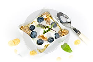 Corn flakes with yoghurt, honey, walnuts and blueberries photo