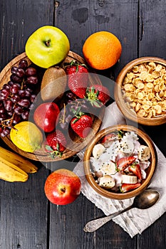 Corn flakes with yogurt and chia seeds. Assorted juicy ripe fruits. Strawberry, kiwi, apple, pear, banana, grapes