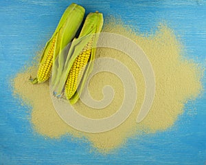 Corn flour and corn on the cob on a wooden table