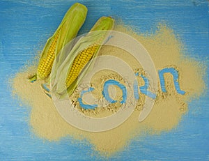 Corn flour and corn on the cob on a wooden table