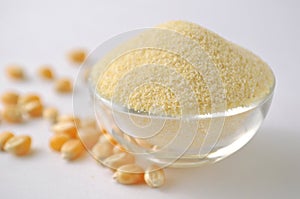 Corn flour and grains on white background. Isolated on white. Yellow powder in a glass bowl. Alternative gluten-free flour