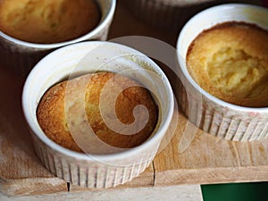 Corn flour sweet muffins in baking ramekins on wooden board