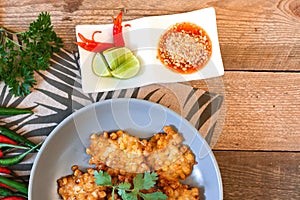 Corn Fritters With chili sauce placed on a wooden table