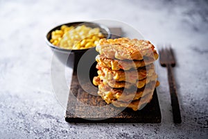 Corn fritters in a plate with sour cream sauce