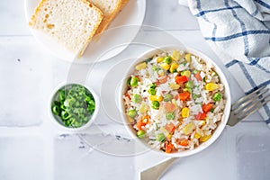 Corn green peas red pepper rice in a plate