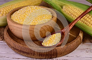 corn grits polenta in a wooden bowl on old wooden table