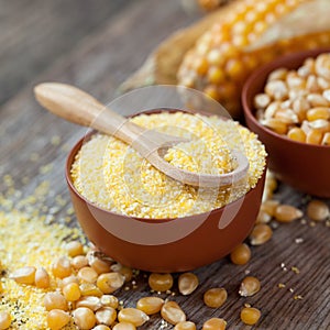 Corn groats in bowl, corn seeds and corncobs