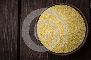 Corn groats on wooden rustic table. Selective focus