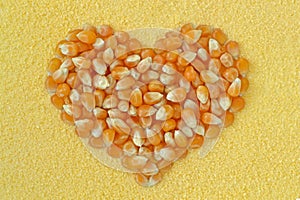 Corn kernels heart on maize flour background