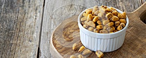 Corn nuts with sauce on wood background.