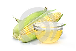 Corn oil in glass bowl with corn on cob isolated on white