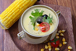 Corn porridge with vegetables on a wooden table