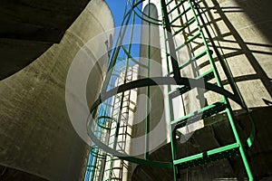 Corn seed storage bin at elevator grain operation in the Midwest surrounded by corn fields