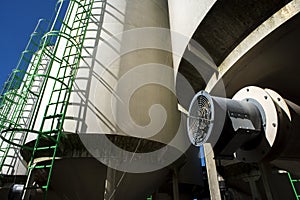 Corn seed storage bin at elevator grain operation in the Midwest surrounded by corn fields