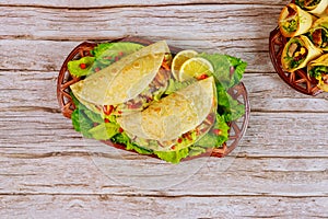 Corn soft tortillas stuffed with lettuce, meat and cheese on wooden background. Mexican dish