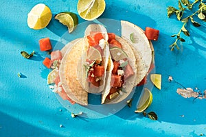 Corn taco shell with watermelon and feta salad, sprinkled lime photo