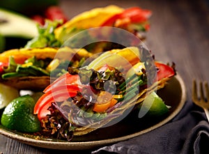 Corn tortilla tacos with avocado, tomatoes, onion and lettuce photo