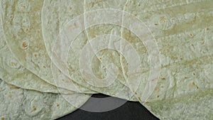 Corn tortillas on black background. Unleavened bread. Mexican tortillas