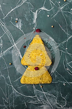 Corn tortillas with cheese. The concept of the new year from the Mexican nachos. Christmas trees from nacho chips on a blue backgr