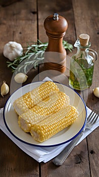 Corn on white plate with herbs, rustic kitchen setting