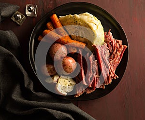 Corned beef,cabbage,carrots and red potatoes on black plate photo