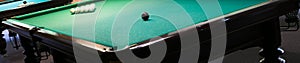 Corner of a billiard table with white and black balls on it