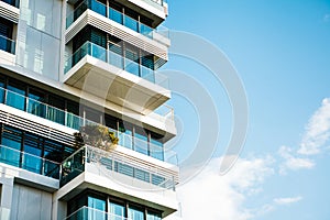 The corner of the building with many windows against the blue sky