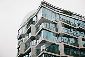 The corner of the building with many windows against the gray sky