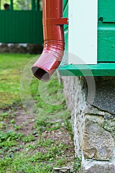 Corner of building with red metal drainpipe