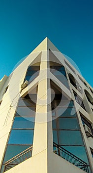 corner of an Egyptian architecture University or school building, white building, blue glass, beautiful clear blue sky