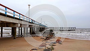 The corner formed by the construction of a bridge into the sea and picturesquely located stones on the seashore. photo