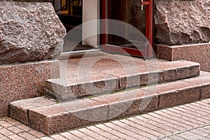 Corner of granite steps to entrance with open door.