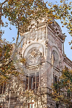 Corner of the High Court of Justice of Catalonia building among autumn foliage photo