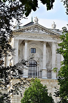 Corner of historic building, in the museum district in Vienna, with portico and statues.