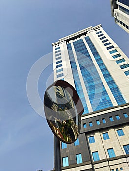 corner mirror in front of a building with clear  blue sky  at office yard