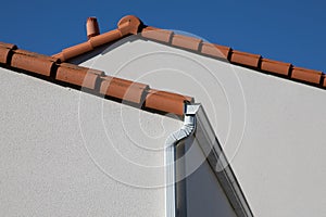 Corner of modern new facade house with gutter and ventilation chimney